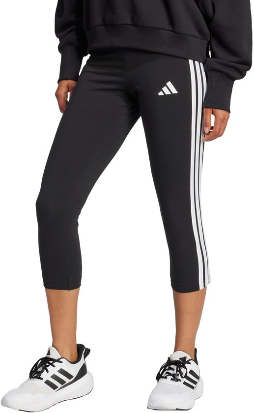 Zwarte 3/4 legging voor dames met witte Adidas strepen op de zijkant en een Adidas logo.