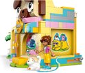 Animalerie LEGO Friends avec une enseigne de chat et de chien sur la façade. Une mini-poupée en pantalon jaune et un chaton blanc se tiennent devant.
