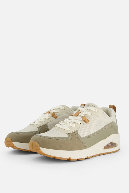 Deux baskets Skechers beiges avec lacets blancs, détails en suède marron et mesh, sur fond blanc.
