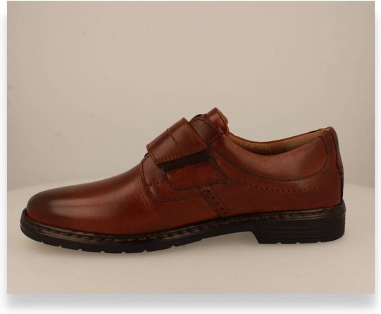 Cognac leren schoen met een gesegmenteerde klittenbandsluiting, gestikte details en leren voering.
