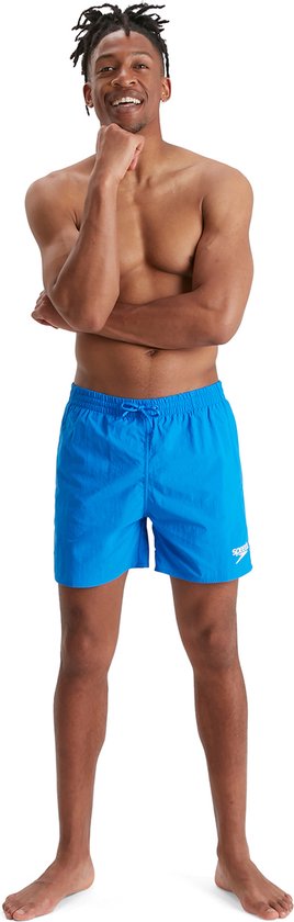 Homme avec le menton sur la main, portant un short de bain bleu.