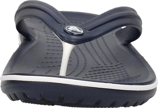 Donkerblauwe Crocs flipflop met witte strepen op de zoolrand. De bandjes zijn donkerblauw met een witte tussenruimte.