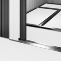 Close-up van de schuifdeur en de metalen rails van een donkergrijs tuinhuis, met een glimp van de witte vloer.