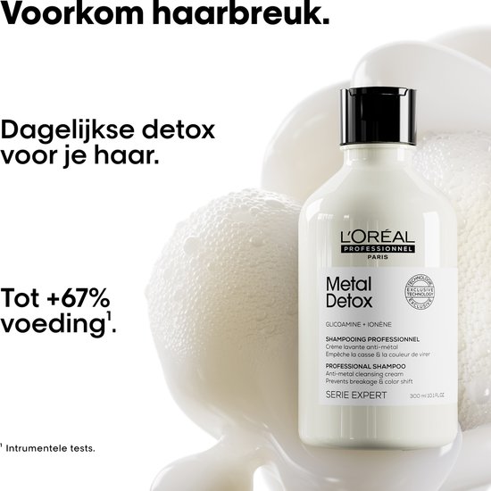 Fles L'Oréal Professionnel Metal Detox shampoo naast schuim en een badstof.