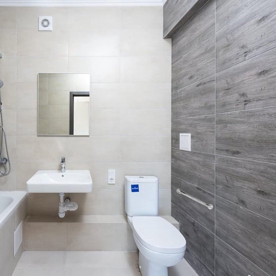 Moderne badkamer met een betegelde muur en douchezitje.