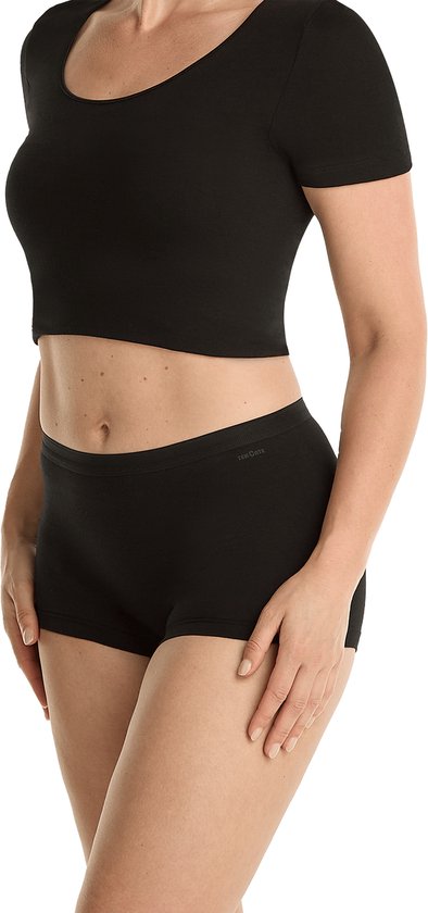 Zij-aanzicht van een vrouw die een zwarte crop top en een zwarte short draagt.