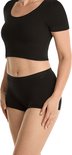Zij-aanzicht van een vrouw die een zwarte crop top en een zwarte short draagt.