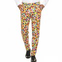 Man met de handen in de zakken, draagt een broek met confettiprint en zwarte schoenen.