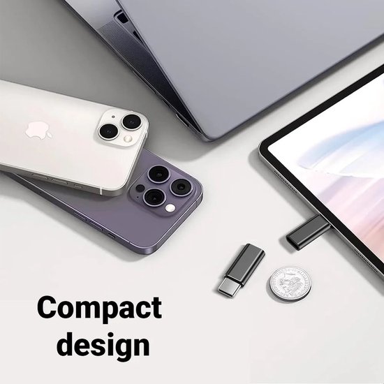 Compacte adapter naast iPhones, MacBook en tablet. Een munt is ter vergelijking.