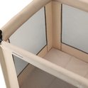 Close-up van de bovenrand en de gaaszijde van een beige reisbedje.