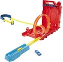 Une piste de course Hot Wheels avec une base de lancement rouge 'jerrican', une boucle orange, des virages bleus et une voiture bleue et blanche.
