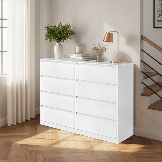 Commode blanche à 8 tiroirs dans une pièce avec parquet et fenêtre.