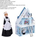 Dienstmeisje pop naast een gestileerd blauw-wit poppenhuis met veel details.
