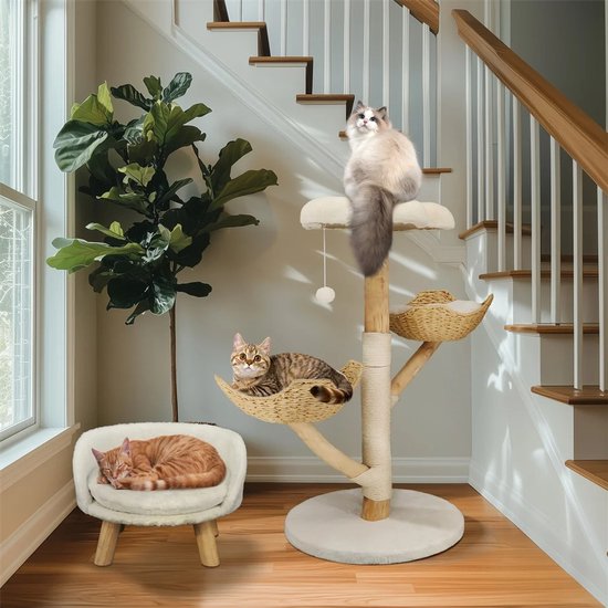 Houten kattenkrabpaal met mandjes, met twee katten. Een kat slaapt op een stoel naast de krabpaal.