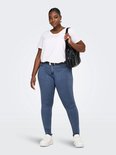 Model draagt een blauwe skinny jeans met een witte t-shirt, zwarte riem en tas.