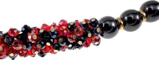 Detail van een armband met rode en zwarte kristallen en zwarte hematietkralen.