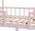 Close-up van het roze kinderbed frame met witte spijlen en houten lattenbodem.