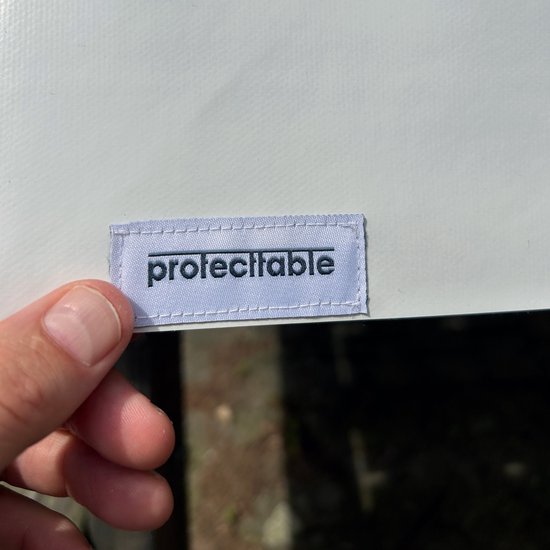 Étiquette avec le texte 'protecttable' tenue par une main.