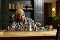 Vrouw bouwt aan een LEGO set van De Wegisweg met kleurrijke gebouwen.