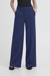 Model van voren gezien in een donkerblauwe, wijde broek met rechte pijpen en een hoge taille.