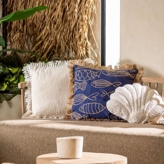 Close-up van sierkussens op een beige bank: wit met franjes, blauw met goudkleurige visjes.