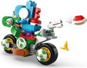 Een groene Lego-motor met een blauwe Yoshi, die een schild afschiet. Een gele banaan ligt ernaast.