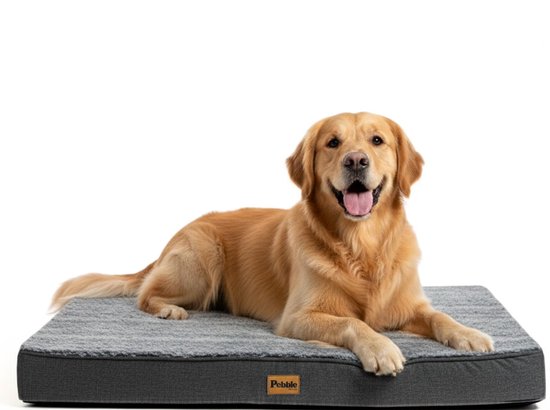 Un Golden Retriever heureux est allongé sur un coussin pour chien rectangulaire gris foncé avec une surface douce. Le coussin a une étiquette Pebble marron.
