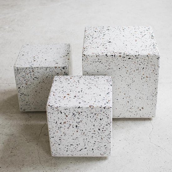 Drie kubusvormige bijzettafels met terrazzo-look in wit met veelkleurige spikkels.