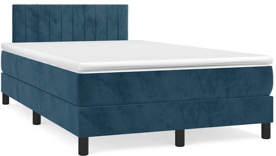Donkerblauwe boxspring met gestreept hoofdbord, matras en zwarte poten.