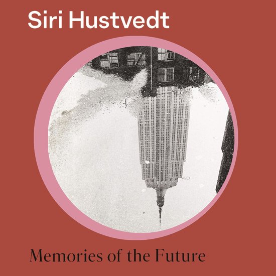 Boekhoes met de tekst 'Siri Hustvedt' en 'Memories of the Future'. Een cirkel toont de reflectie van de Empire State Building in een plas.