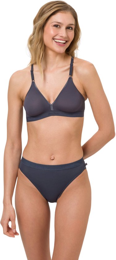 Model in grijze beugelvrije bh en slip. De bh heeft lichte naden op de cups en een elastische band.
