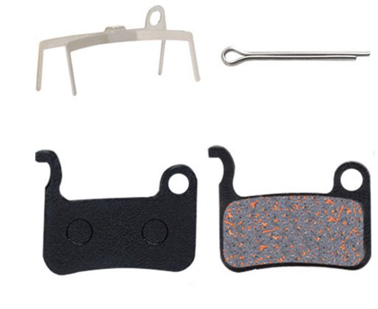 Twee zwarte remblokken, een metalen veerclip en een pen.