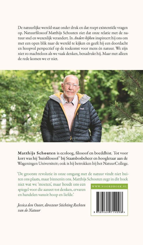 Matthijs Schouten, ecoloog, filosoof en boeddhist, lacht naar de camera. Hij draagt een donkere jas met gele capuchon.