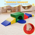 Een speelset van gekleurde schuimblokken (groen, rood, geel, blauw) met een tunnel en hellingen, getoond op een beige tapijt.