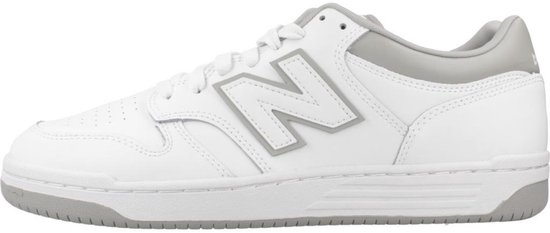 Witte lage sneaker van New Balance met grijze accenten en een groot grijs 'N' logo op de zijkant.