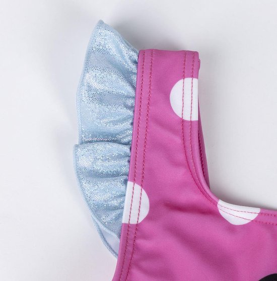 Detail van de schouder en glitter ruche mouw van een roze badpak met witte stippen.