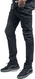 Voeten van een man in zwarte skinny jeans en zwarte hoge Vans sneakers.