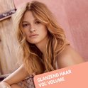 Vrouw met goudbruin, golvend, volumineus haar.