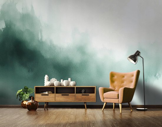 Un salon avec un papier peint photo abstrait peint en vert, une commode en bois, un fauteuil orange et un lampadaire.