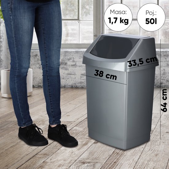Une poubelle Curver argentée avec un couvercle gris, à côté d'une personne en jean.
