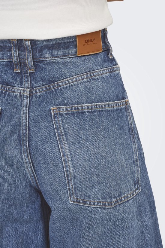 Close-up van de achterkant van een middendonkere, wijde spijkerbroek met hoge taille. Vierkante achterzakken.