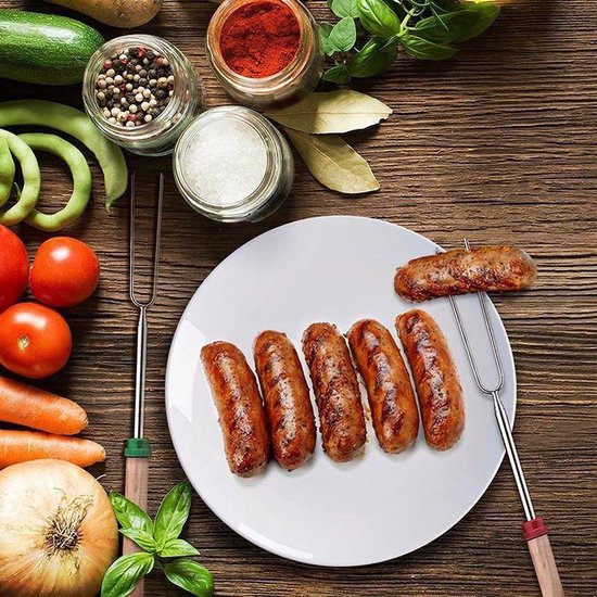 Gegrilde worstjes op een spiesje, naast andere worstjes op een bord. Ingrediënten op de achtergrond.