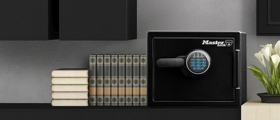 Zwarte Master Lock kluis met digitaal cijferslot, op een plank naast boeken.
