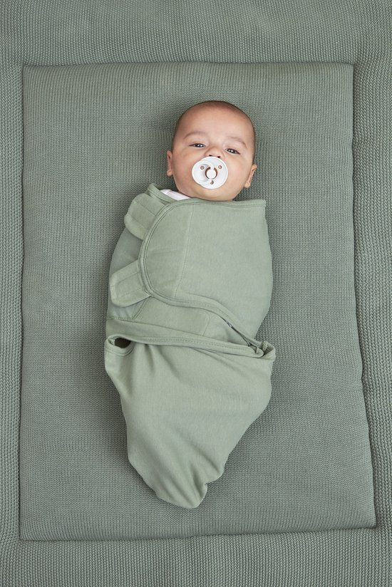 Baby ingebakerd in een saliegroene Meyco inbakerdoek met speentje.