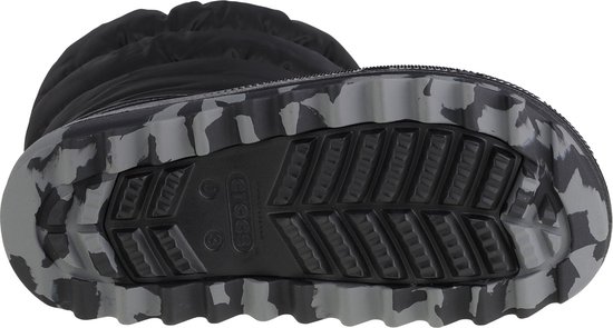 Zool van een zwarte Crocs kinder sneeuwlaars met grof profiel en camouflagepatroon.