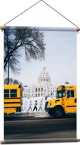 WallClassics - Textielposter - Gele Schoolbussen bij Gebouw - 60x90 cm Foto op Textiel