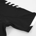Detail van een zwart sportshirt met mesh op de zijkanten, witte strepen op de mouw en witte boord.