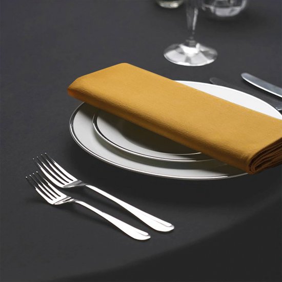Gele servet op een gedekte tafel met bestek en servies.