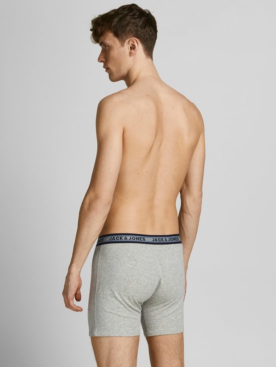 Man, van achteren gezien, draagt een lichtgrijze Jack & Jones boxer met blauw logo-elastiek.