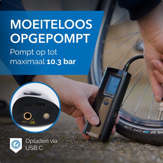 Zwarte Donrox compressor met digitaal display en USB-C poort, terwijl een hand de fietspomp gebruikt.